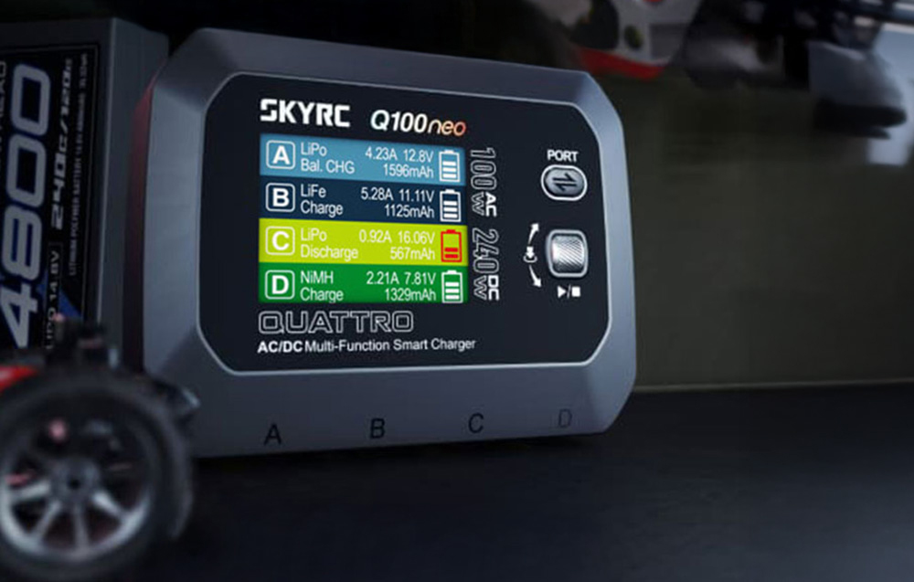Zbliżenie na ekran ładowarki SKYRC Q100neo wyświetlający parametry ładowania czterech kanałów.